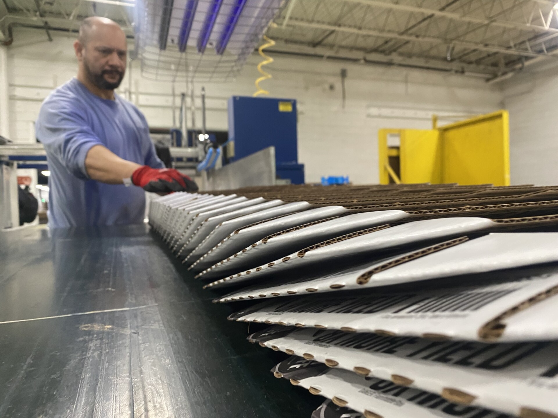 Digital printing press actively running branded folding cartons